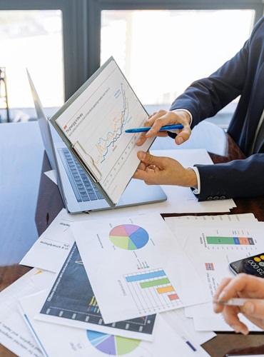 Business professionals discussing financial graphs and charts in an office setting.